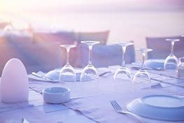 A table with wine glasses and plates on it