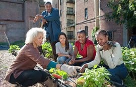 A group of people sitting around some plants