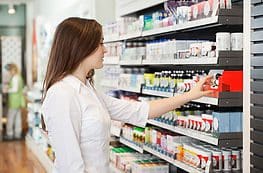 A woman is shopping in the store for milk.