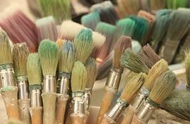 A bunch of paint brushes are sitting on the table