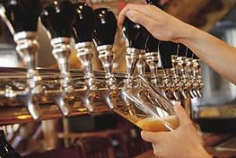 A person pouring beer into a glass.