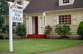 A house for sale sign in front of a home.