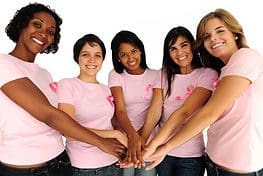 A group of people in pink shirts holding hands.