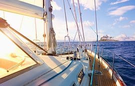 A boat is sailing on the ocean under a blue sky.