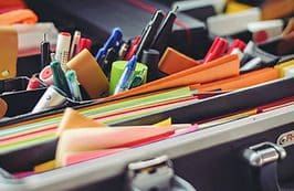 A table with many different pens and pencils.