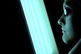 A woman looking out of the window at night.